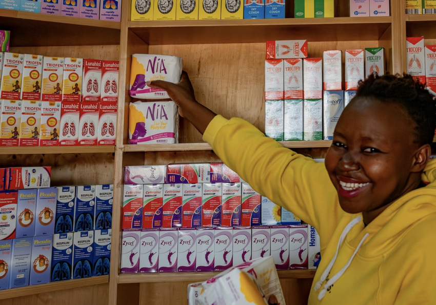 An entrepreneur proudly displays her new menstrual hygiene products on a tidy shelf