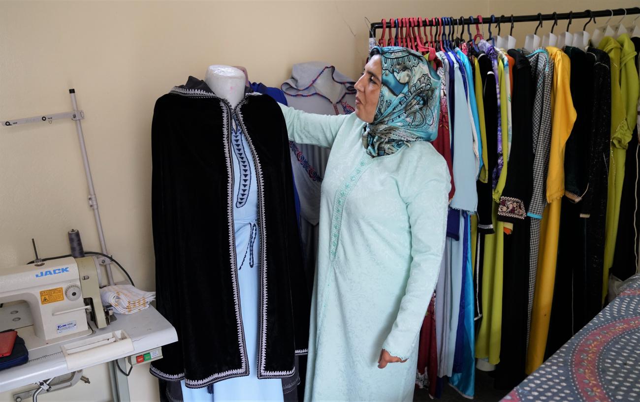 Woman holding a outfit she made